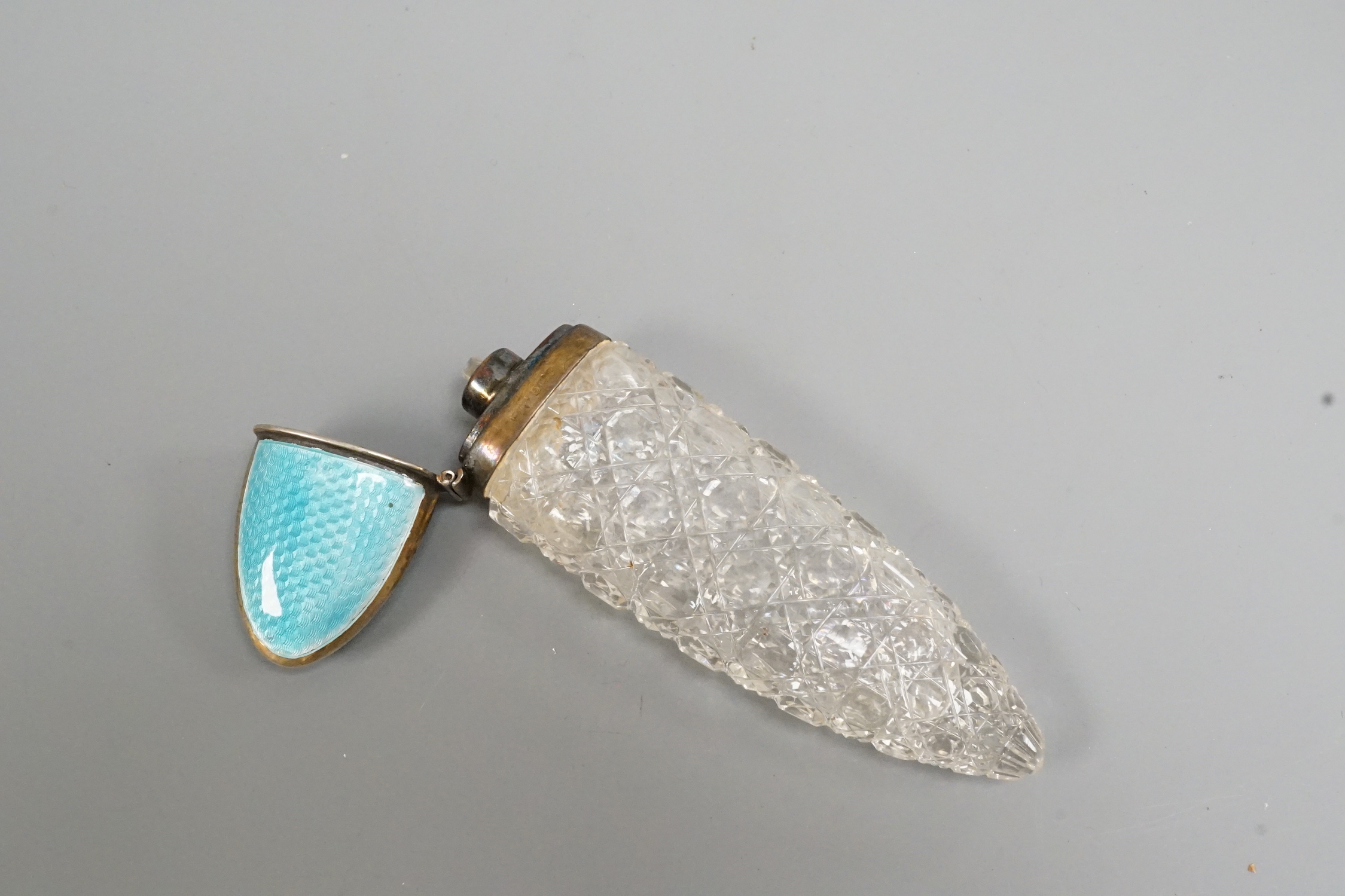 An early 20th century silver and blue enamel mounted cut glass scent bottle, Birmingham, date letter rubbed, 12cm.